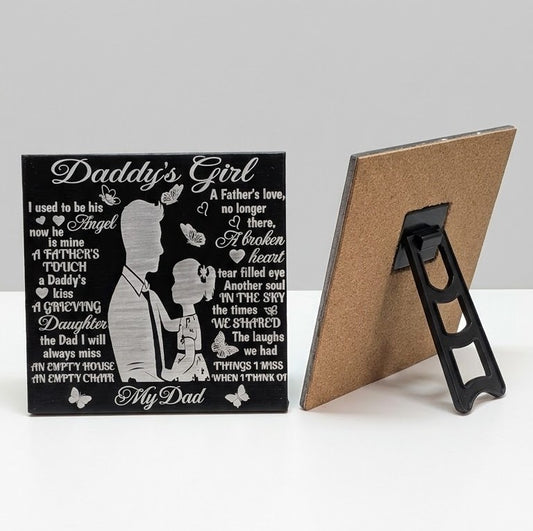 Daddy’s Girl laser engraved ceramic dad memorial tile showing a father and daughter silhouette, with cork backing and black plastic stand shown alongside.